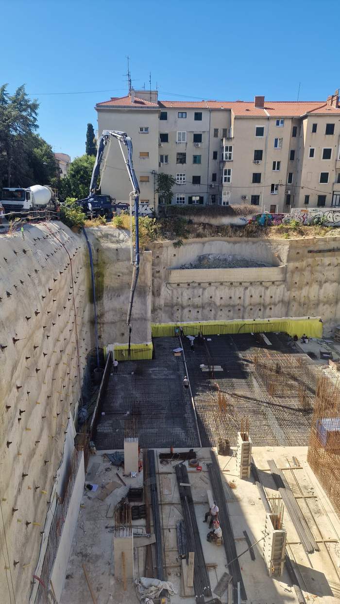 Pumpa spušta beton u duboku građevinsku jamu