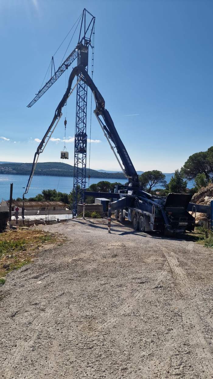 Autopumpa za beton s razvučenom granom uz toranjski kran